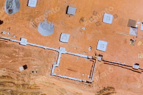 Preview: Construction site showing foundation preparation with concrete blocks materials in an arid landscape