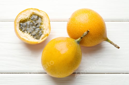 Preview: Ripe passion fruits on white wooden table, flat lay