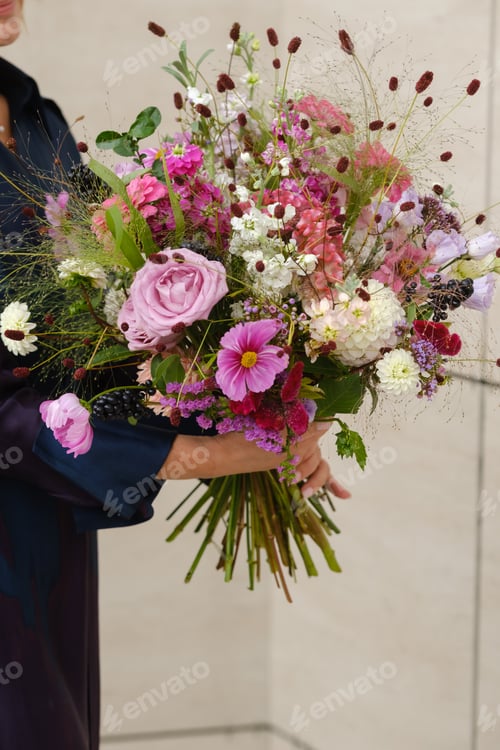 Preview: A large bouquet of mixed flowers in the hands of a woman. The work of a florist in a flower shop