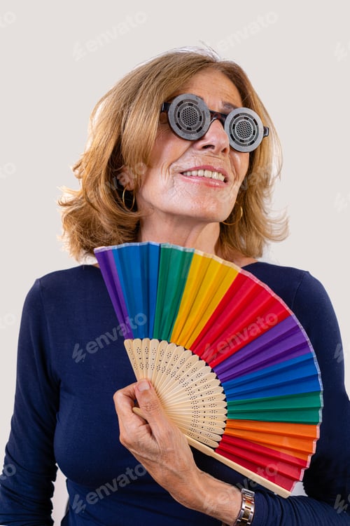 Preview: senior fit caucasian 60s confident woman holding rainbow fan over white background