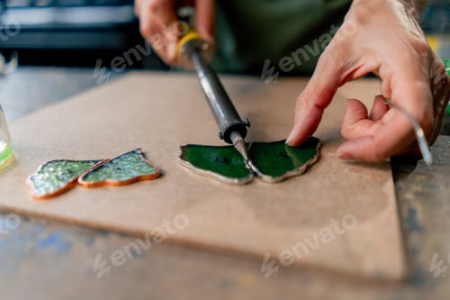 Preview: close up in a large green workshop on a woman with green hair creates decorative flowers working