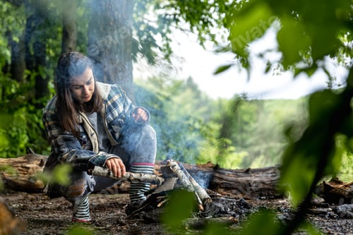 Preview: A girl on a hike in the woods prepares a fire.