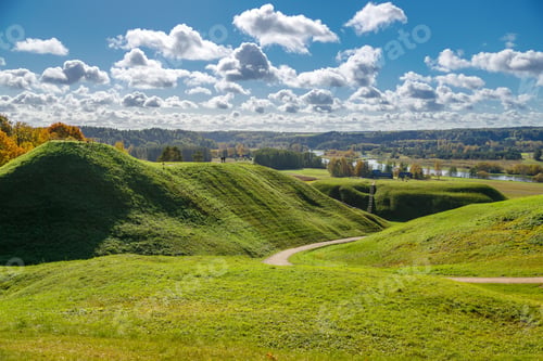 Preview: Scenic view of rolling grassy hills and a winding walking path in Kernavė, Lithuania