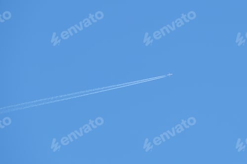 Preview: Distant passenger jet plane flying on high altitude on clear blue sky leaving white smoke