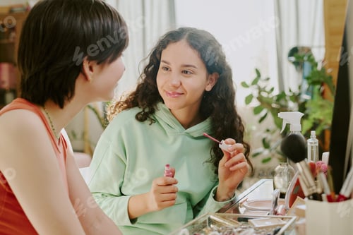 Preview: Smiling Young Girl Applying Pink Nail Polish