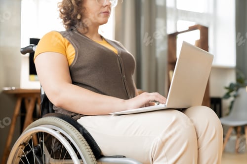 Preview: Young contemporary businesswoman of creative designer in wheelchair typing