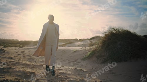 Preview: Woman resting sand dunes posing in sunlight. Stylish african american admiring