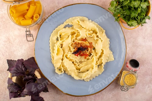 Preview: a top view dough pasta cooked tasty salted inside round blue plate with flower and raw pasta on the