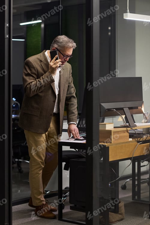 Preview: Middle Aged Man Talking on Smartphone While Working in Office