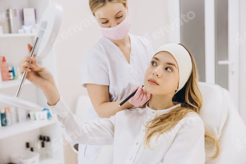 Preview: Cosmetologist marking facial injection sites for botox procedure in professional aesthetic medical