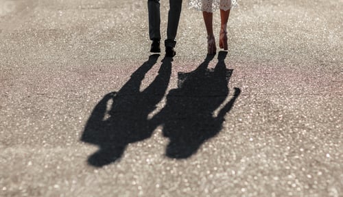 Preview: Shadows of a young couple walking down the street holding hands. Bright sunny day. Newlyweds go fa