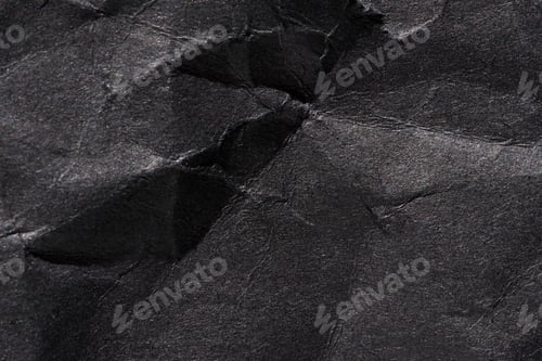 Preview: Textured black wrinkled paper surface with creases and shadows for abstract or background design