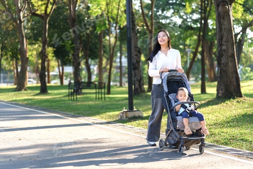 Preview: Mother pushing baby in stroller walking in park