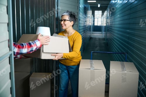 Preview: Lady with short hair hands over packed things
