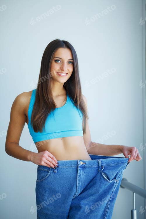 Preview: Diet. Dieting concept. Woman in Sportswear Measuring Her Waist