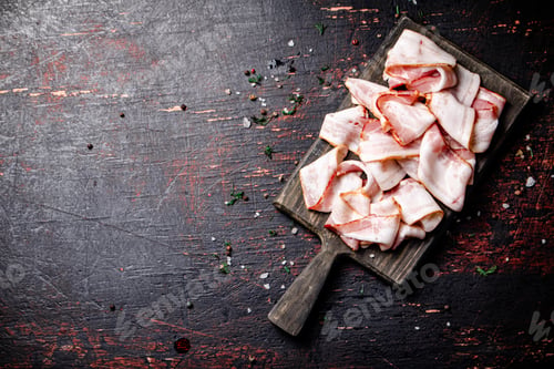 Preview: Pieces of fresh bacon on a cutting board with spices.