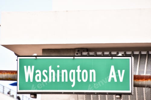 Preview: Street plaque on the building wall with the text ''Washington Av'' in Miami