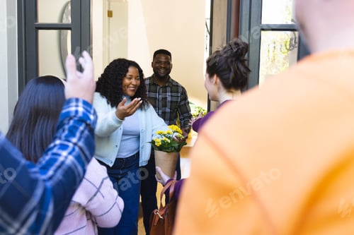Preview: Happy african american couple receiving guests in sunny house