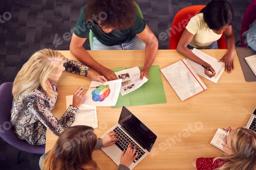 Preview: Overhead Shot Of University Or College Students Sitting Around Table With Tutor In Lesson