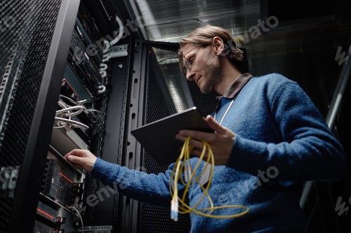 Preview: Middle Aged Caucasian Man Managing Server Equipment in Data Center Facility