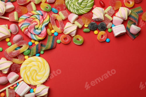Preview: Different delicious candies and marshmallows on red background, flat lay. Space for text