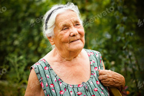 Preview: Close up portrait of a senior woman in a garden. Very old lady of eighty years old outdoor in summer