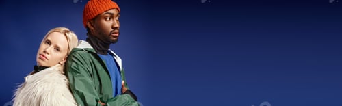 Preview: young blonde woman leaning on african american man in winter attire, diverse models on blue, banner
