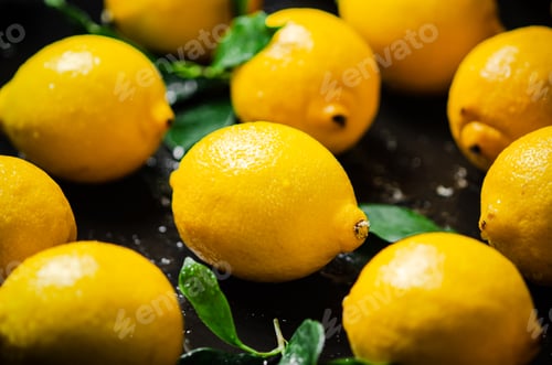 Preview: Fresh lemons. On black table.