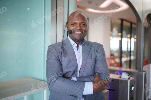 Preview: Portrai of African American businessman using laptop of mobile device in modern office.