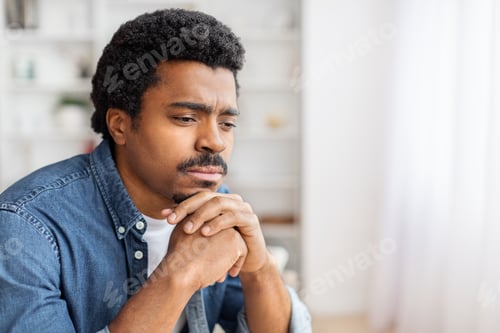 Preview: Pensive man looking away with hands clasped