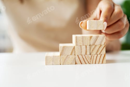 Preview: Female hand arranging wood block stacking as step stair