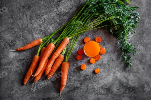 Preview: Fresh carrots and carrot juice on dark background. Sliced vegetables full of vitamins.