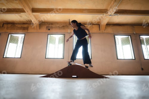 Preview: skater woman playing skateboard in sport gym, happy and fun with skateboarding lifestyle in city