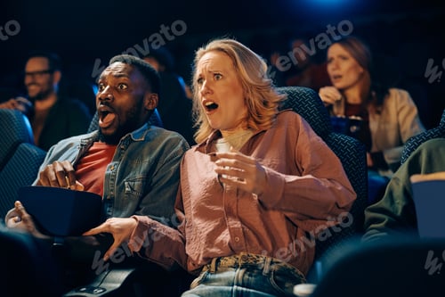 Preview: Frightened couple watching crime movie in a theater.