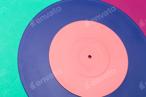 Preview: Colorful vinyl record resting on a vibrant surface, showcasing its unique design and texture