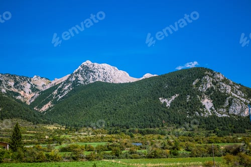 Preview: Beautiful scene of Pedraforca mountain on grass fields under blue sky, Catalonia, Spain