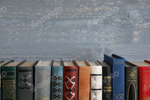 Preview: Stack of hardcover books on grey wooden background. Space for text