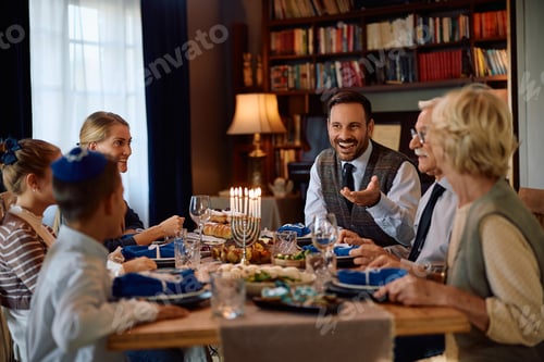 Preview: Happy Jewish multigeneration talking while having lunch at dining table on Hanukkah.
