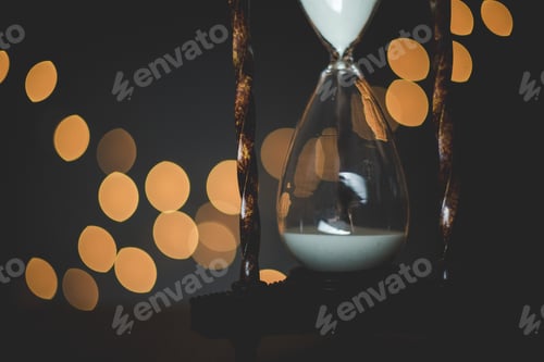 Preview: Closeup shot of a sand glass with blurred lights in the background