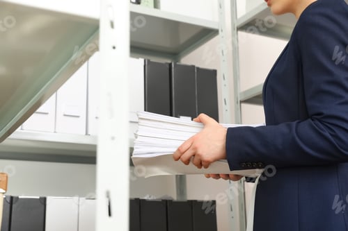 Preview: Female worker with documents in office, closeup