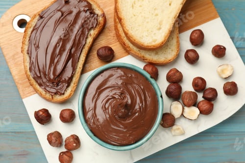 Preview: Toast with tasty chocolate hazelnut spread and nuts on blue wooden table, top view