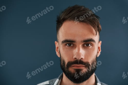Preview: Close up portrait. Handsome man is in the studio against blue background
