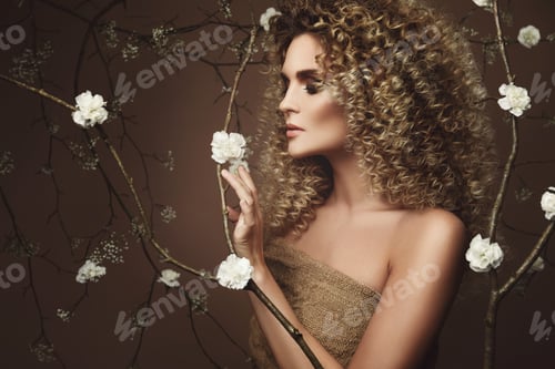 Preview: Lovely young woman with Afro hairstyle and beautiful make-up with a lot of white flowers
