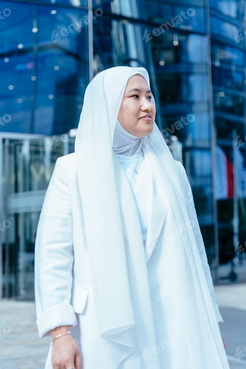 Preview: Confident Muslim woman standing in front of glass building