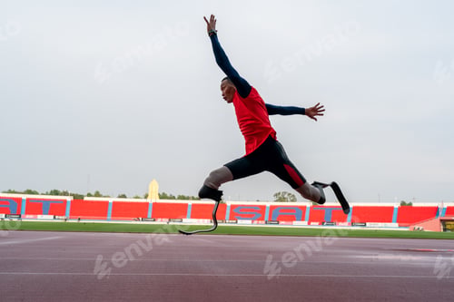 Preview: Asian para-athletes with prosthetic blades sprint on a running track at stadium.