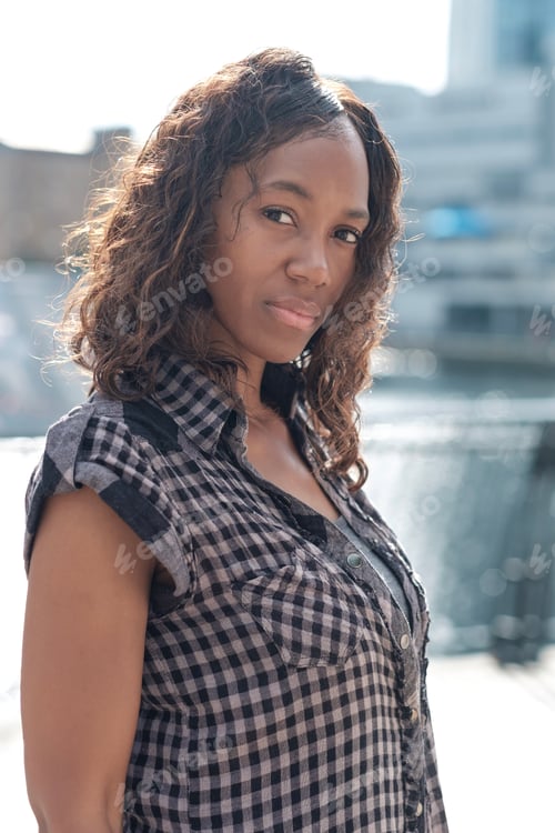 Preview: Portrait of mature black woman with the sun behind her.
