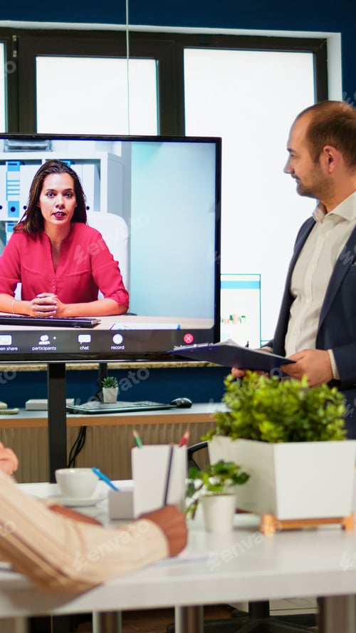 Preview: Diverse business team having videomeeting in broadroom