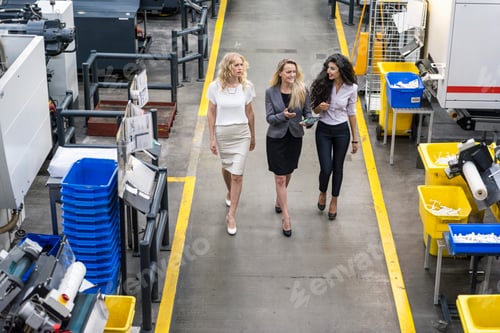 Aperçu: Trois femmes avec tablette marchant et parlant dans l'atelier de l'usine