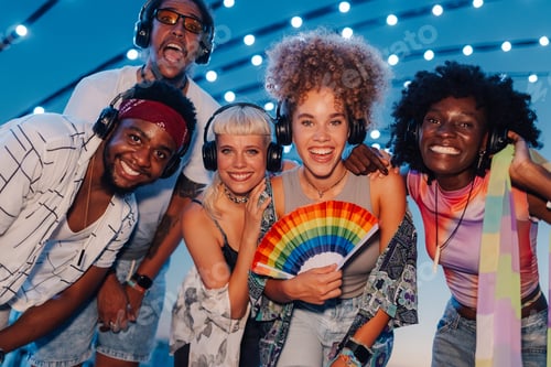 Preview: Friends enjoying silent disco at pride festival with rainbow fan