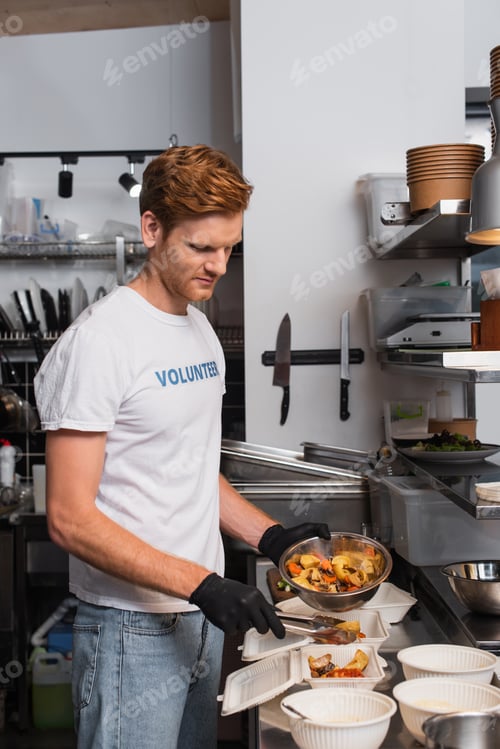 Preview: redhead social worker in latex gloves holding bowl with prepared food near plastic containers